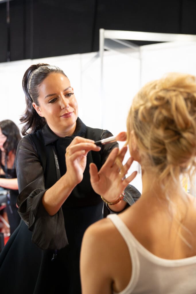 Keira Smyth applying bridal makeup backstage at The Wedding Show Ireland.