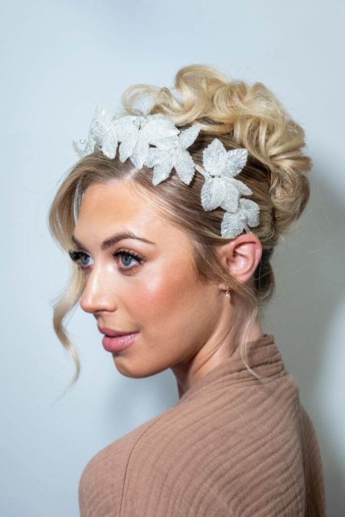 Elegant bridal updo with floral hair accessory styled by Keira Smyth bridal collective.